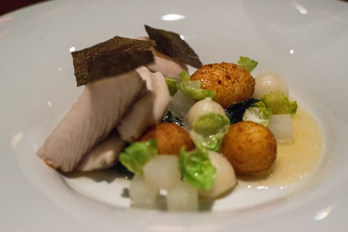 Primer plano de un plato con bacalao negro, nabos y patatas en Aziza, un popular restaurante de San Francisco