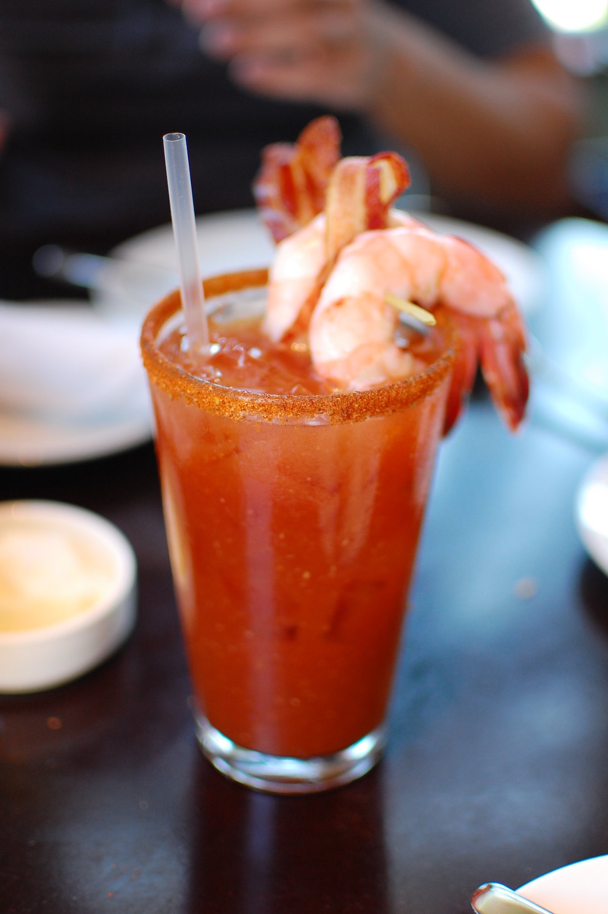 Primer plano de un gallo Bloody Mary con adornos salados y dos guarniciones de camarones jumbo