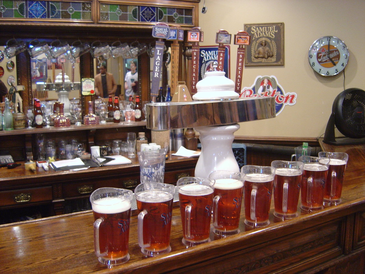 Varias jarras de cerveza alineadas en un bar.