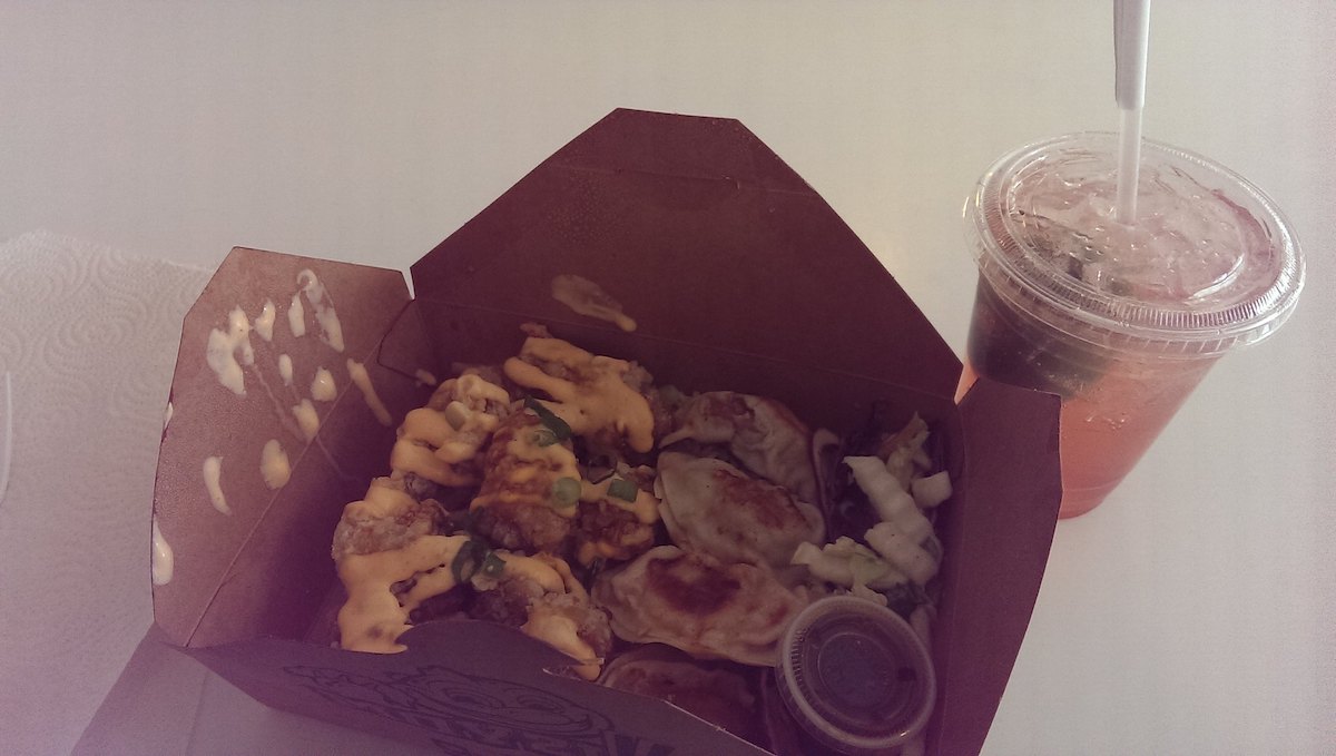 Primer plano de una caja marrón para ir llena de albóndigas chinas. Las albóndigas son de Moyzilla, un camión de comida popular en Boston.