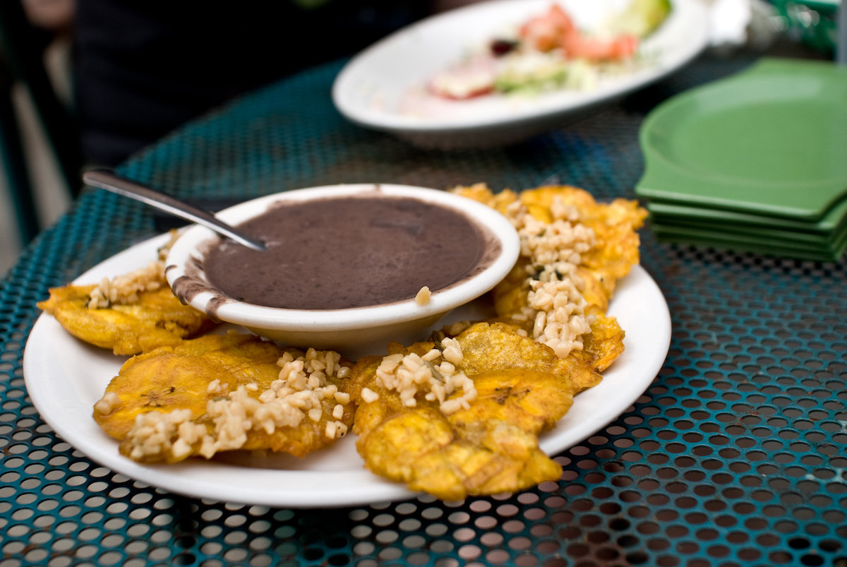 Cerca de un plato de plátanos fritos con salsa de frijol negro en Irazu, un restaurante latinoamericano en Chicago