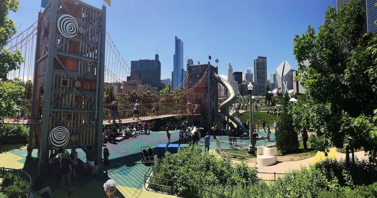 Un gran parque infantil con el horizonte de Chicago al fondo. Maggie Daley Park es un gran lugar gratuito para ir en Chicago con niños.