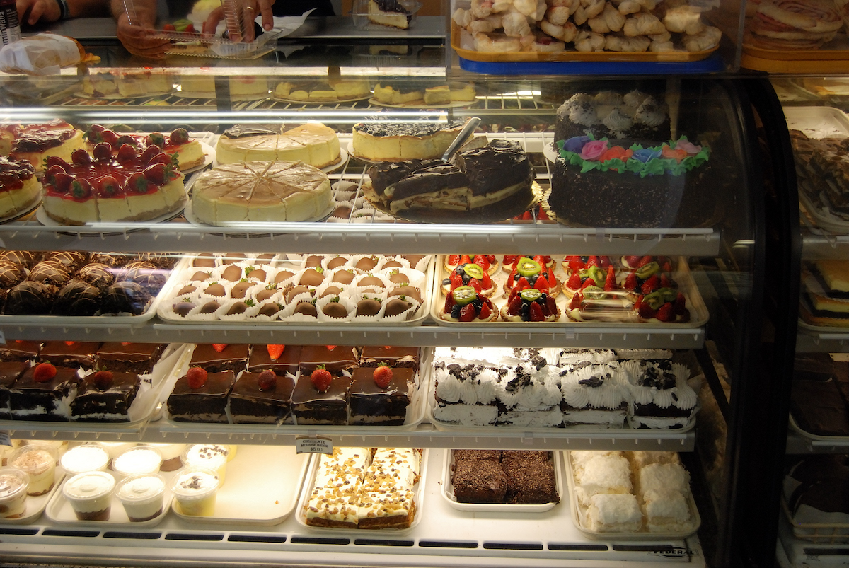 una caja de pasteles llena de pasteles, tartas, pasteles de queso y más en Bova's Bakery en Boston