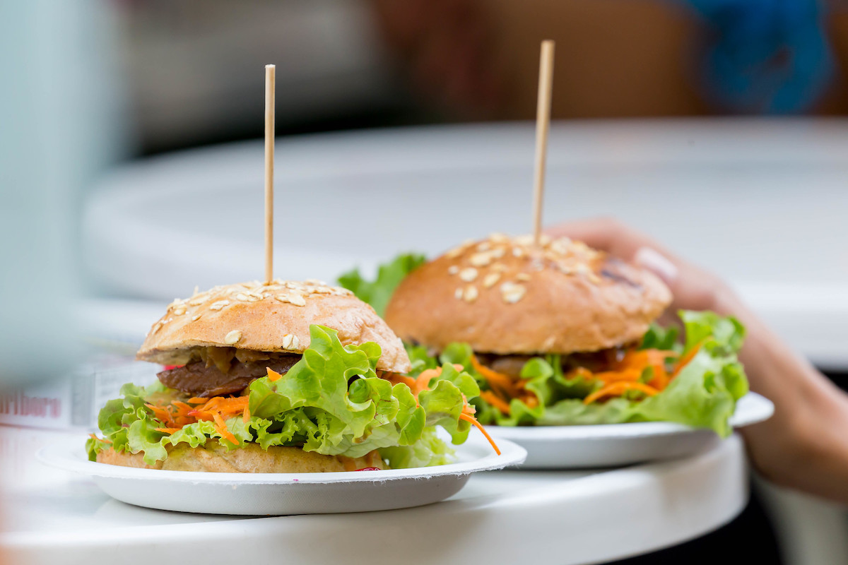Cerca de dos platos blancos con una hamburguesa vegetariana cada uno