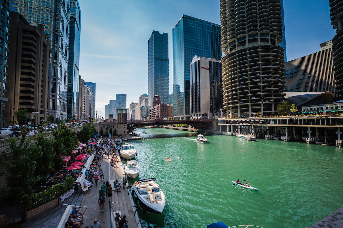 botes pequeños y gente en canoas flotando en el río Chicago y gente caminando por el río
