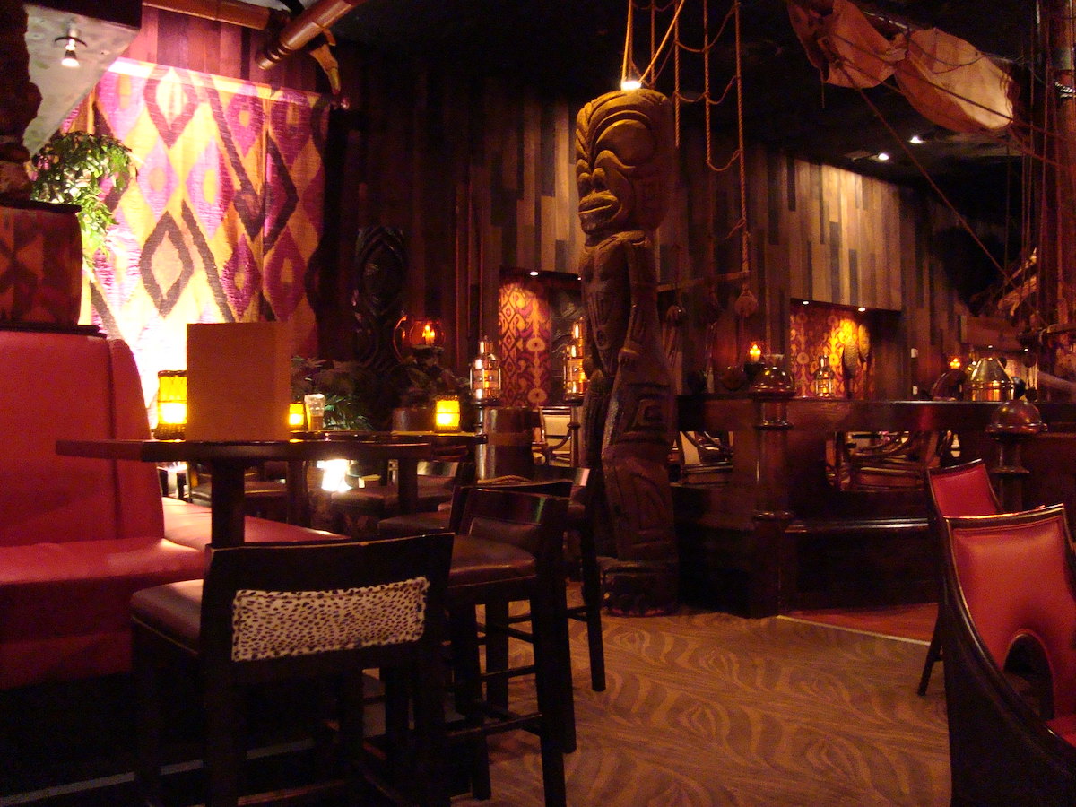 Toma interior del Tonga Room & Hurricane Bar en San Francisco. Se ilumina brevemente con faroles y estatuas tiki alrededor.