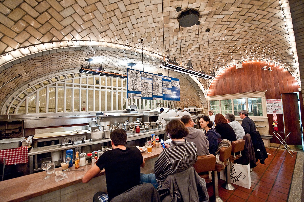 Un comedor bien iluminado donde los clientes pescan desde una estación de tren