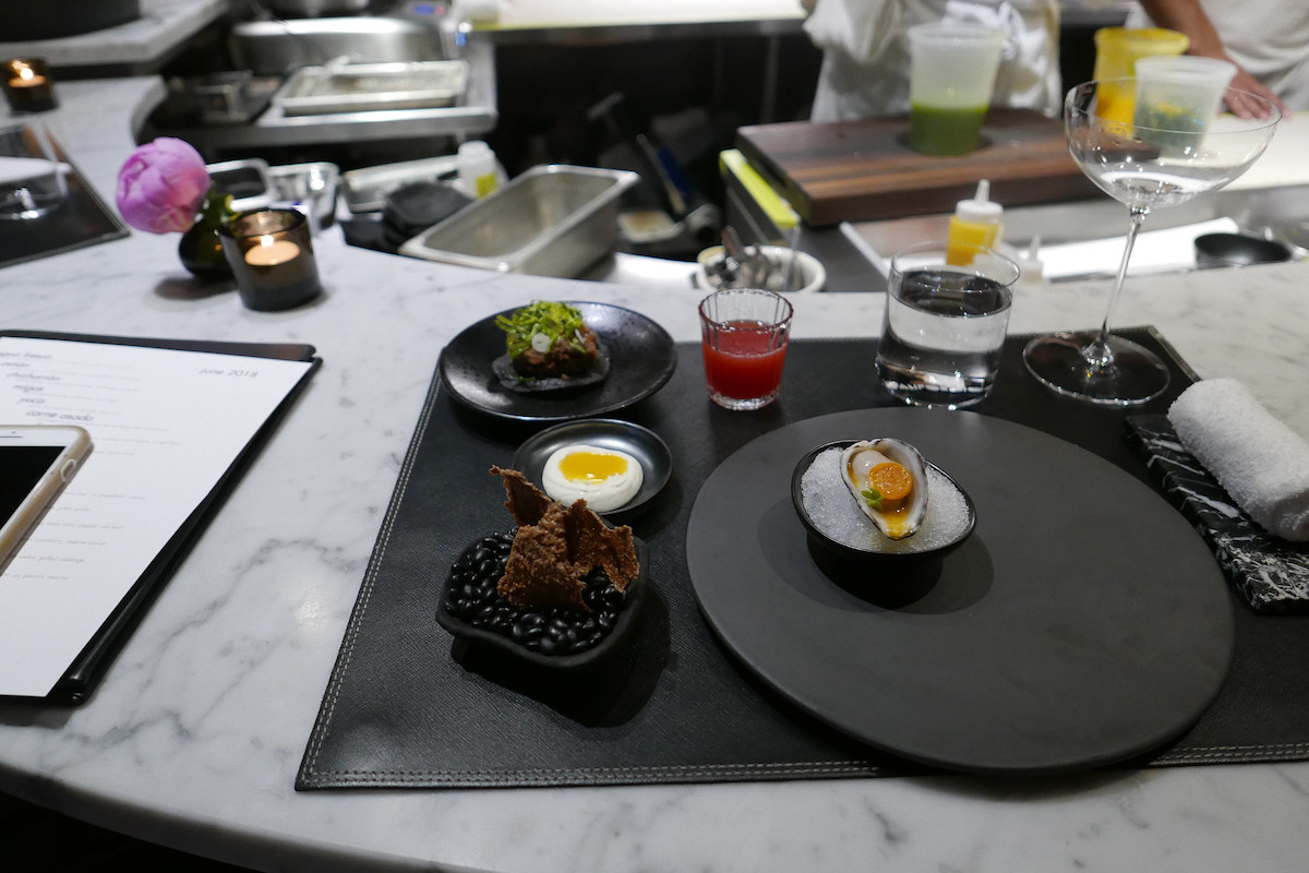 una selección de excelentes entrantes en platos negros en un restaurante con estrella michelin