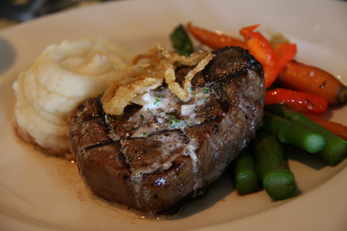 Primer plano de bistec a la parrilla con puré de papas y verduras en Harris Inn and Restaurant