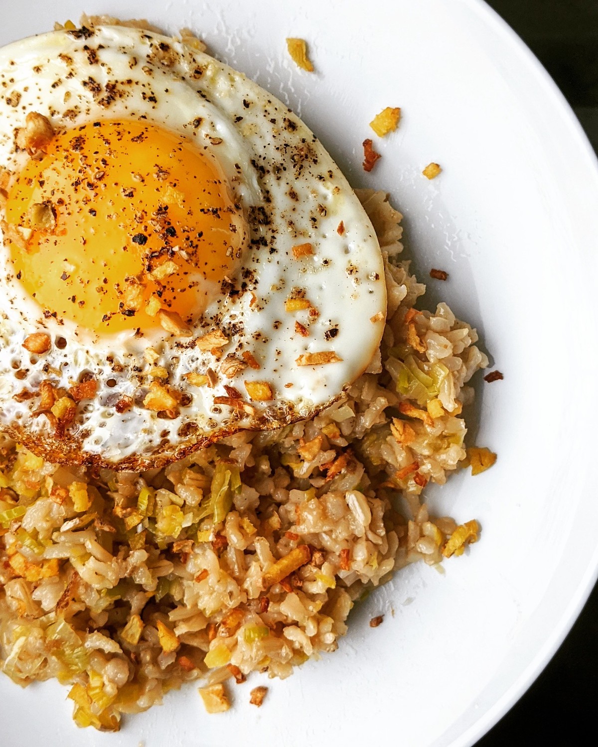 Cierra un plato blanco con arroz frito con jengibre y un huevo frito encima. La receta proviene del chef Jean-Georges de abcV, un restaurante vegetariano en Nueva York.