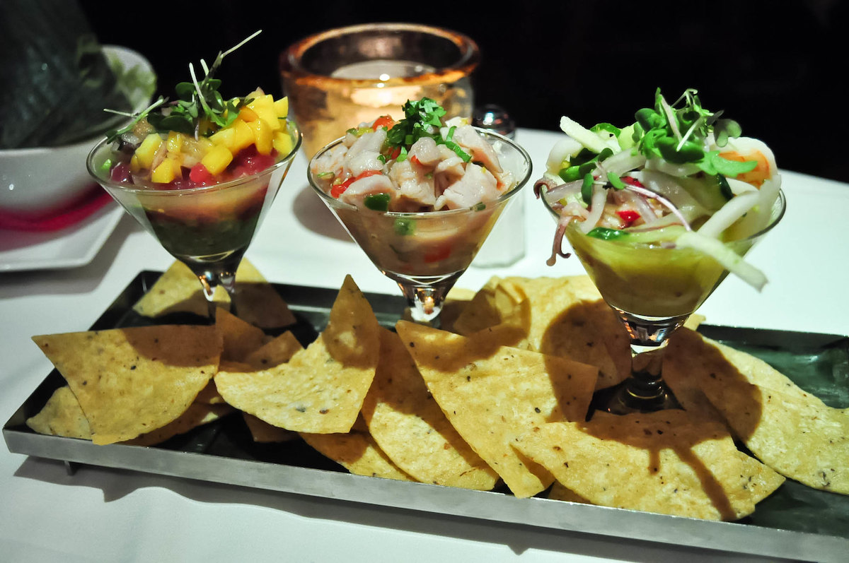 cierre de 3 vasos estilo martini con ceviche, con chips de tortilla en un plato en Topolobampo, uno de los mejores restaurantes de comida mexicana en Chicago