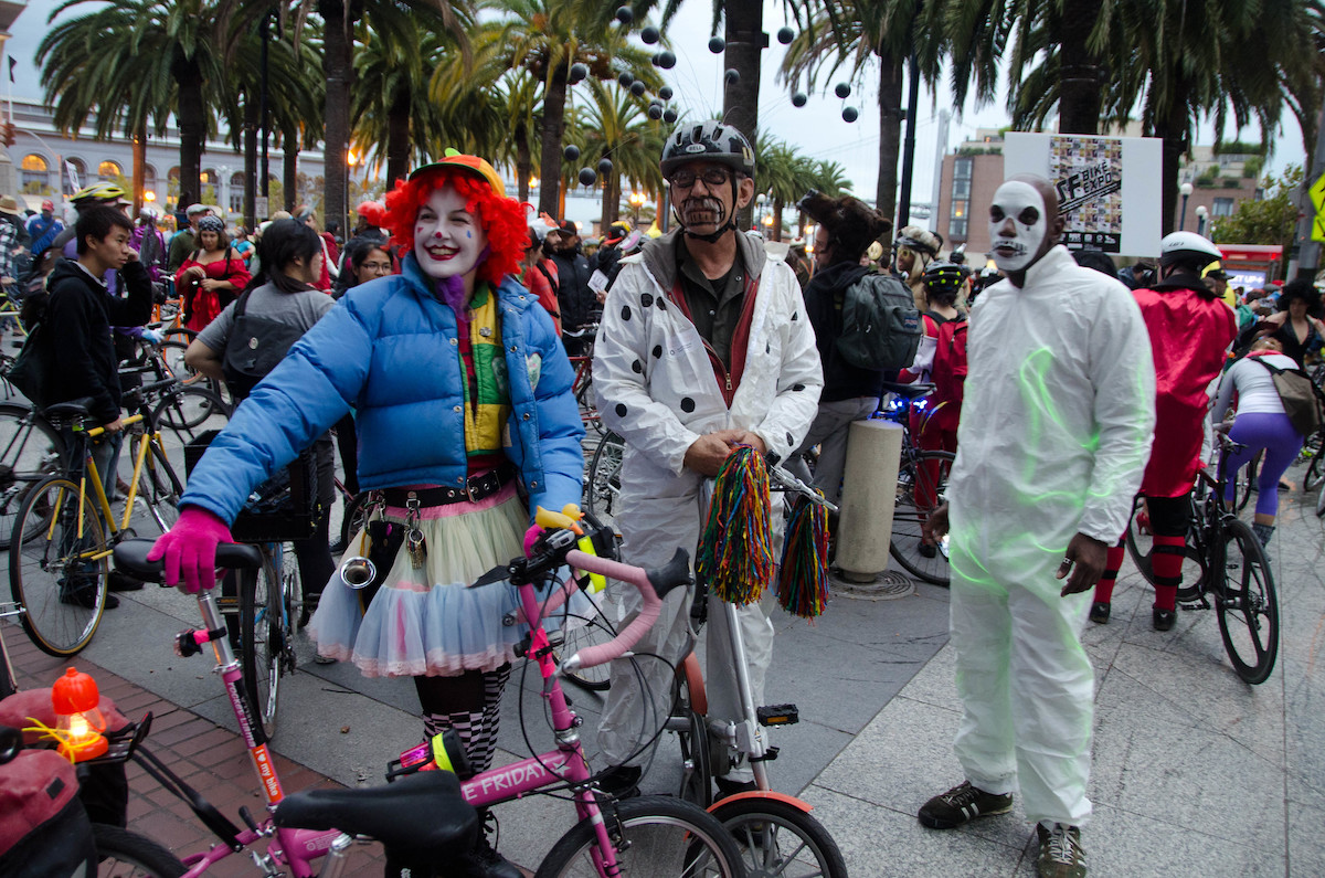 Tres personas disfrazadas de Halloween con sus bicicletas en un evento de Critical Mass en San Francisco