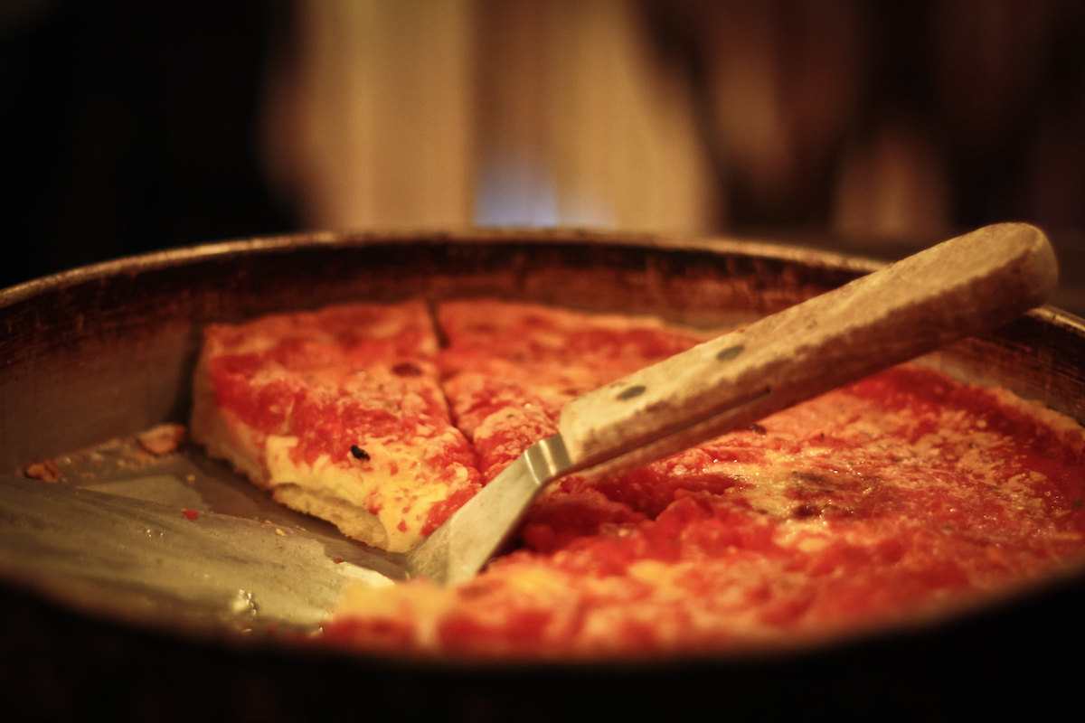 Cerca de una bandeja de pizza de plato hondo y una espátula para servir
