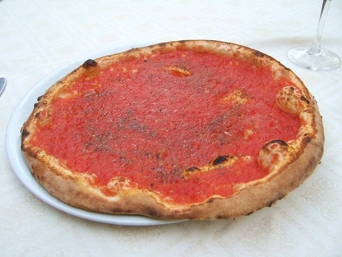 La pizza marinara, un plato vegano natural que se encuentra en Nápoles, es una salsa de tomate con hierbas y ajo encima de la corteza perfecta.