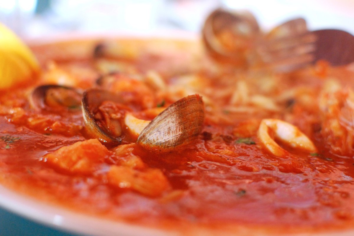Un plato de cioppino, un guiso de mariscos a base de tomate con almejas