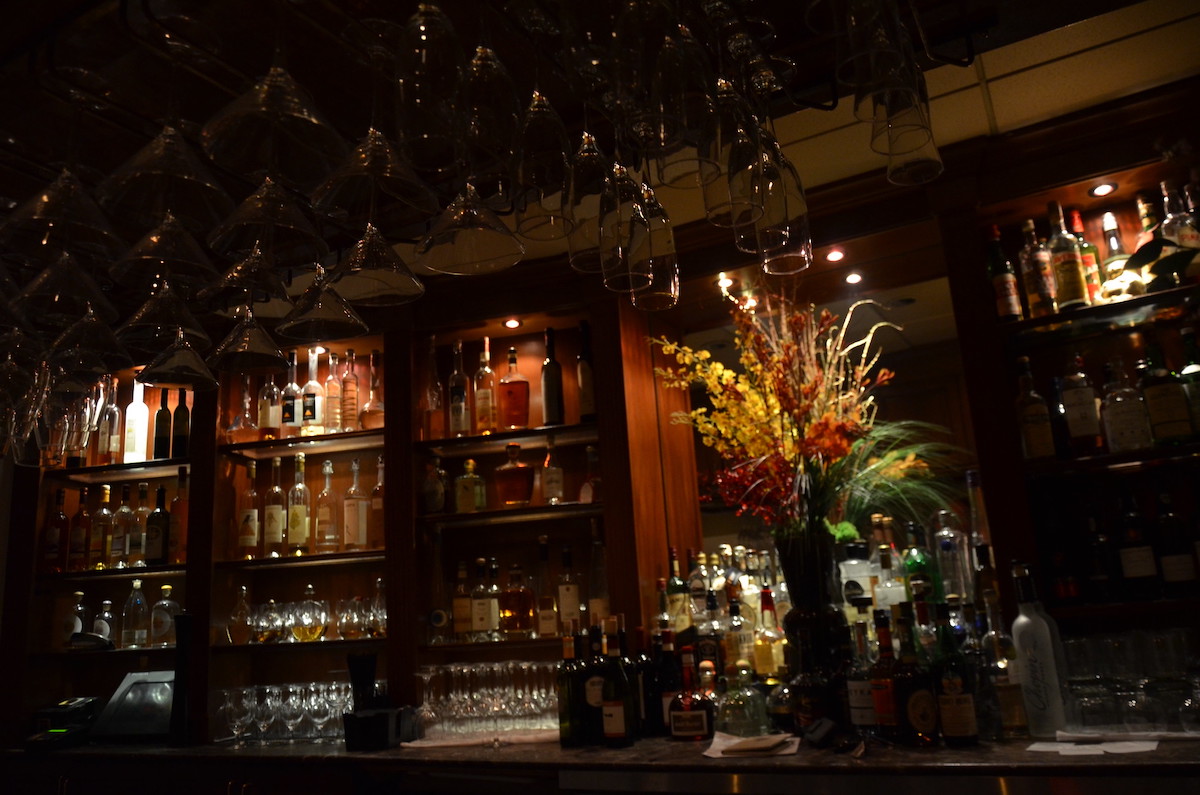 Botellas de licor y cristalería se apilan en los estantes detrás del bar Mamma Maria's en North Boston.