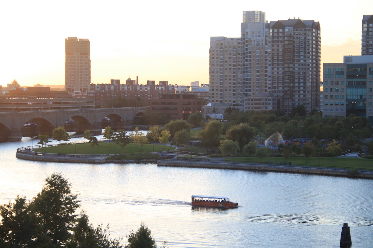 Un vehículo de pato flota en el agua con el horizonte de Boston al fondo