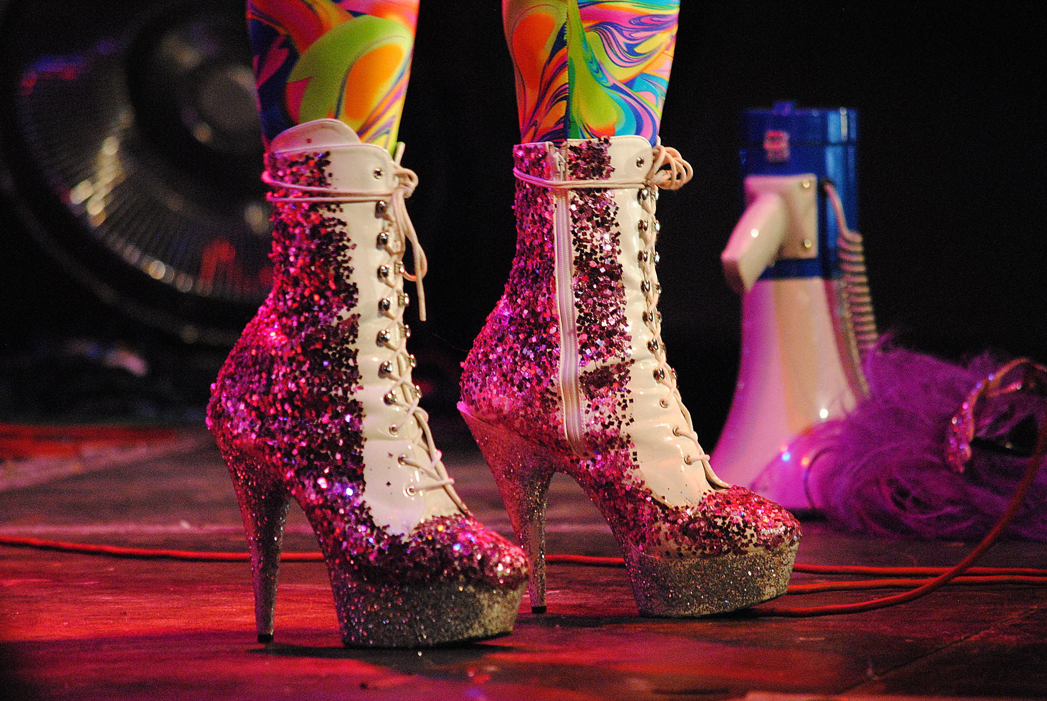 Uno usa zapatos de plataforma de aguja puntiagudos con brillo con un megáfono en el fondo
