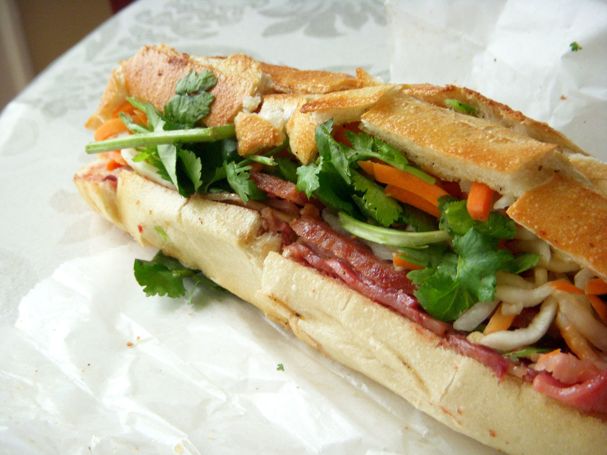 Sándwich banh mi en baguette con cerdo, cilantro y verduras