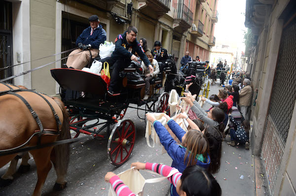 Niños emocionados salen a las calles del barrio de Gracia a recoger caramelos durante la cabalgata de Sant Medir, una de las celebraciones más auténticas que tendrá lugar en Barcelona en marzo.