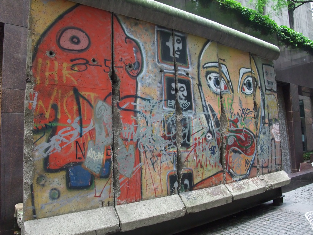 Murales al aire libre pintados sobre losas de hormigón en colores apagados