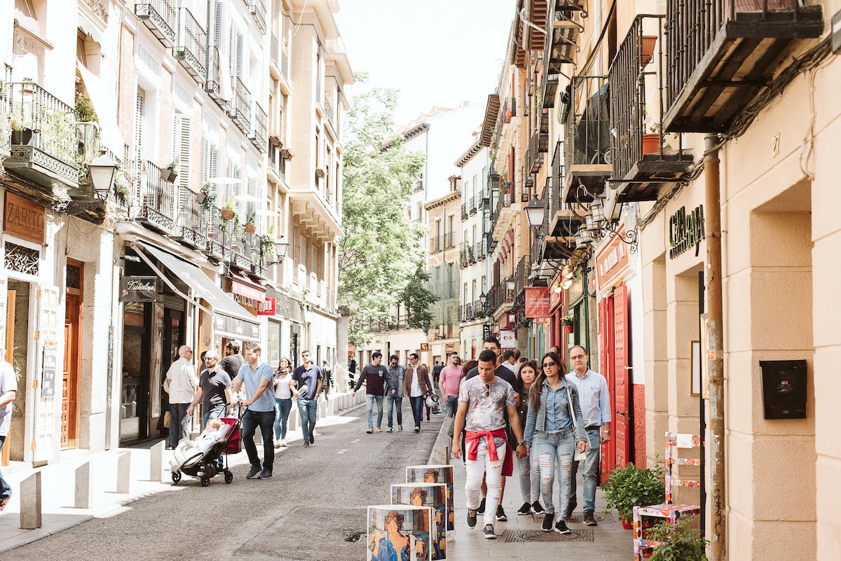 Una calle llena de bares en un barrio urbano en una noche muy concurrida.