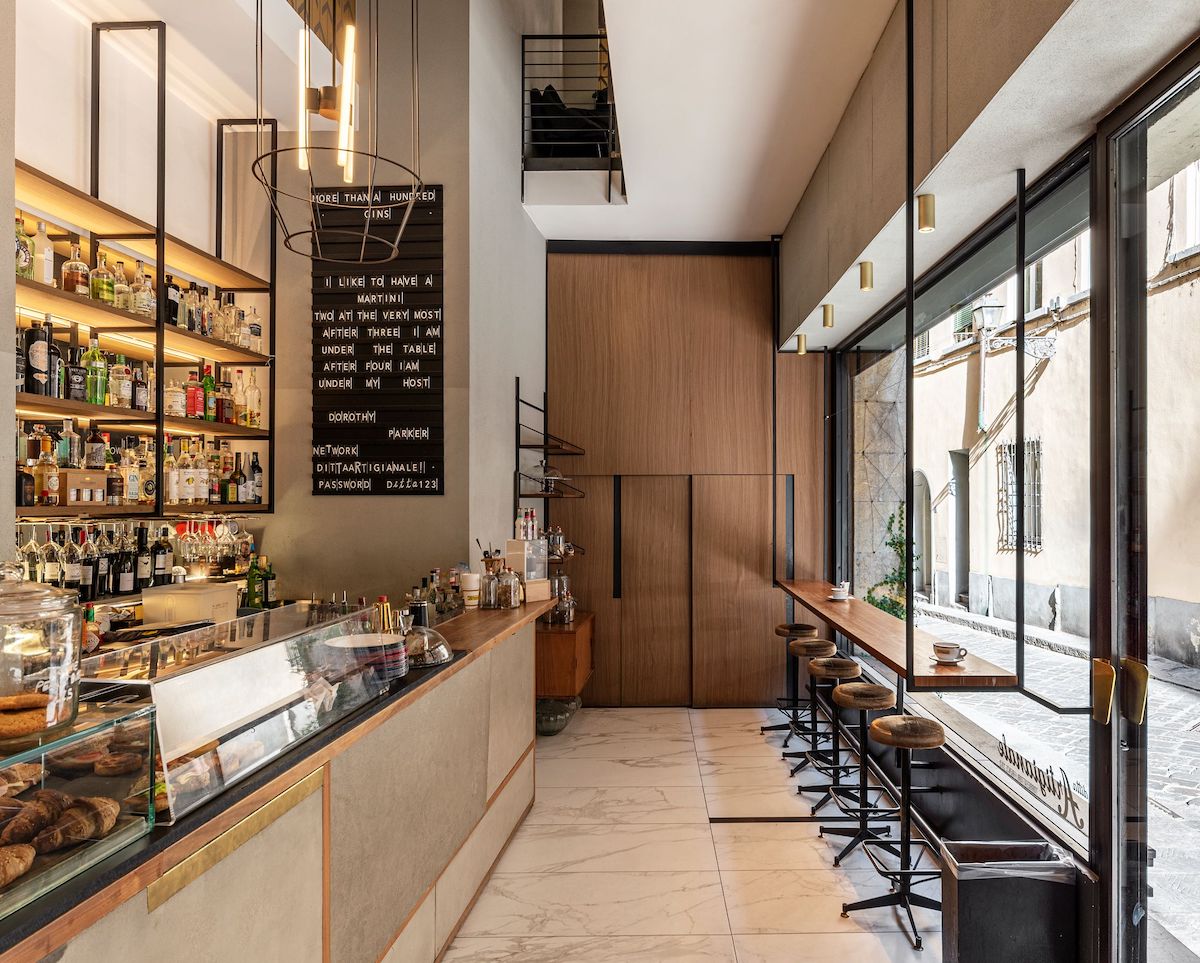 Interior de un café-bar en Florencia en colores neutros con asientos junto a la ventana