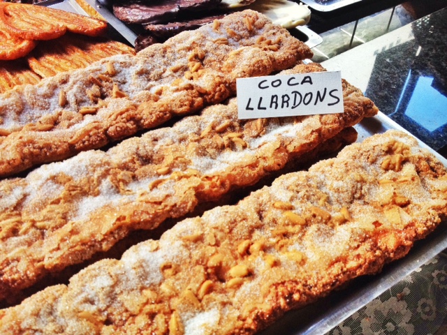 La "coca de llardons" es un pan dulce y crujiente decorado con chicharrones, piñones y azúcar.