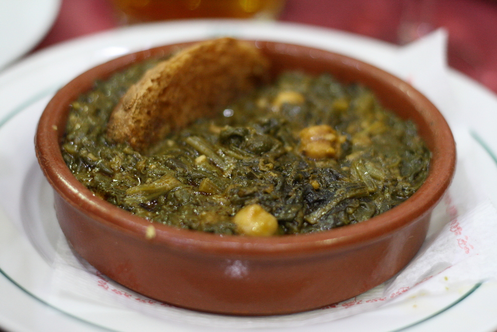 Muy calientes y llenos de sabor, las espinacas y los garbanzos hacen realidad los sueños de comida reconfortante en Sevilla.