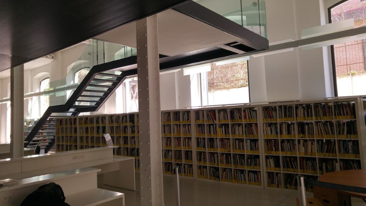 una biblioteca con ventanas negras y escaleras