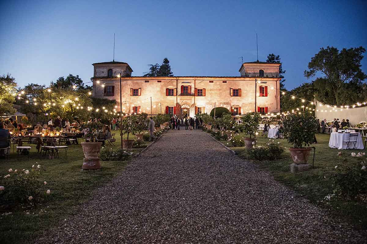 Una majestuosa villa italiana iluminada desde el exterior al atardecer