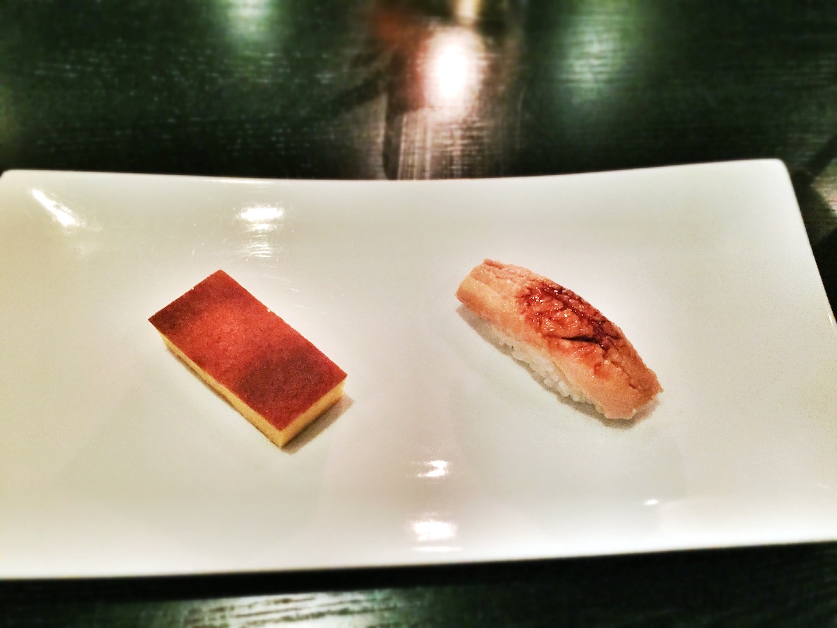Dos piezas de sushi en un plato rectangular blanco.