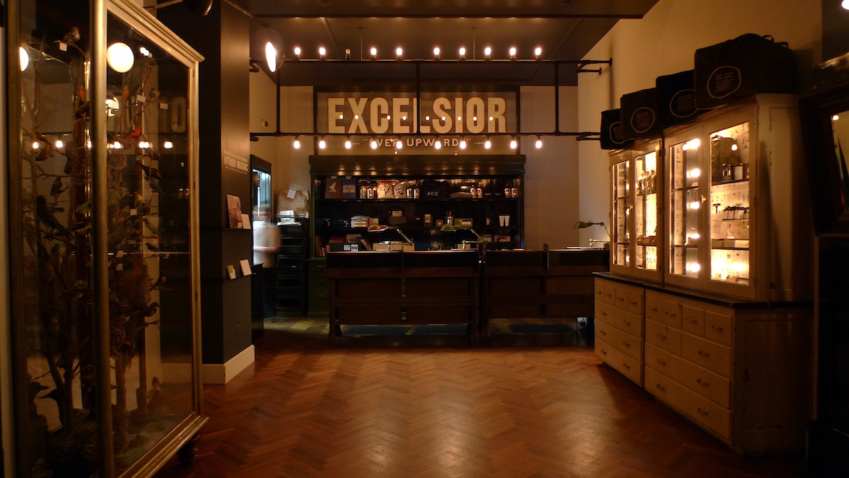 Un mostrador de compras en el vestíbulo de un hotel sin iluminación con la palabra Excelsior en la pared trasera