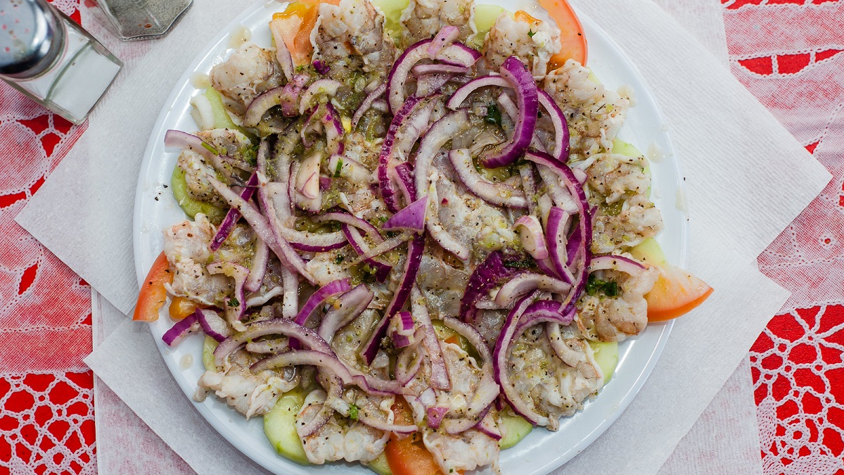 Plato de aguachiles, con mariscos, cebolla morada, pepino y especias