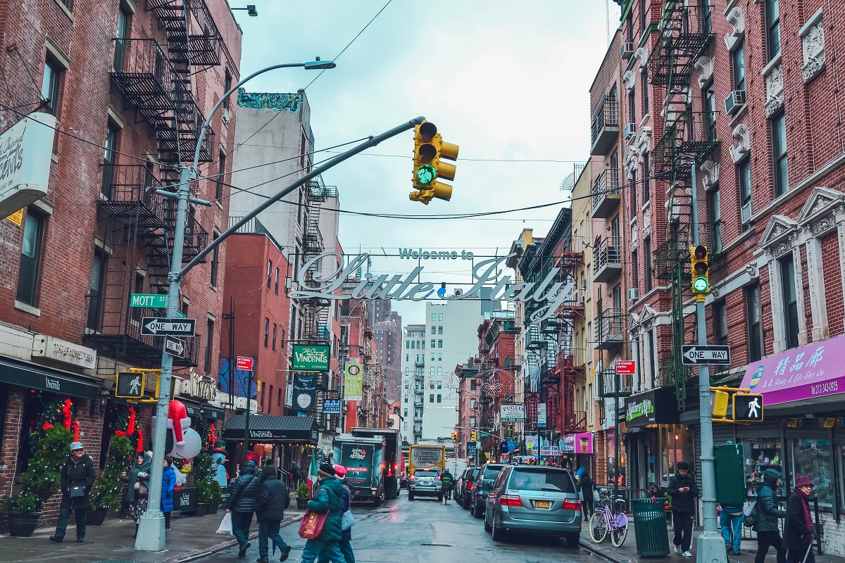 Escena de una calle concurrida en Little Italy en Nueva York, con semáforos, automóviles y peatones