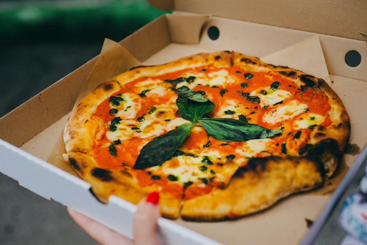 Una pizza minimalista recién horneada de Nápoles con salsa de tomate, queso y albahaca