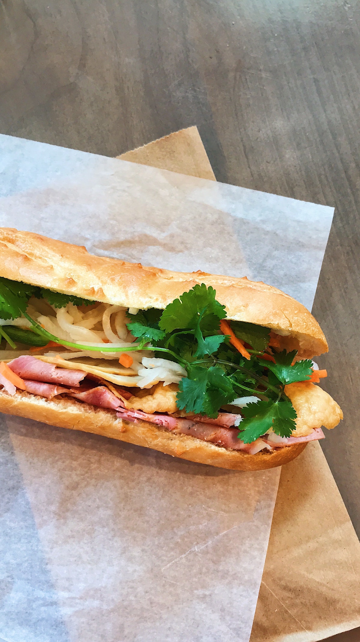 Cierre el sándwich banh mi, baguette cortado largo y relleno de carne y verduras
