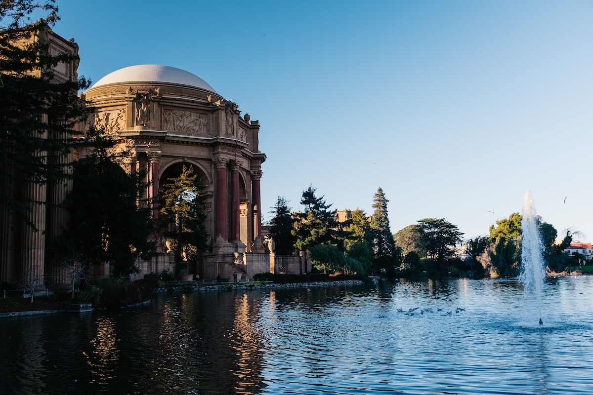 Foto de un estanque con la cúpula del Palacio de Bellas Artes mirando hacia el fondo. Visitar el Palacio de las Artes de San Francisco es una experiencia divertida y gratuita