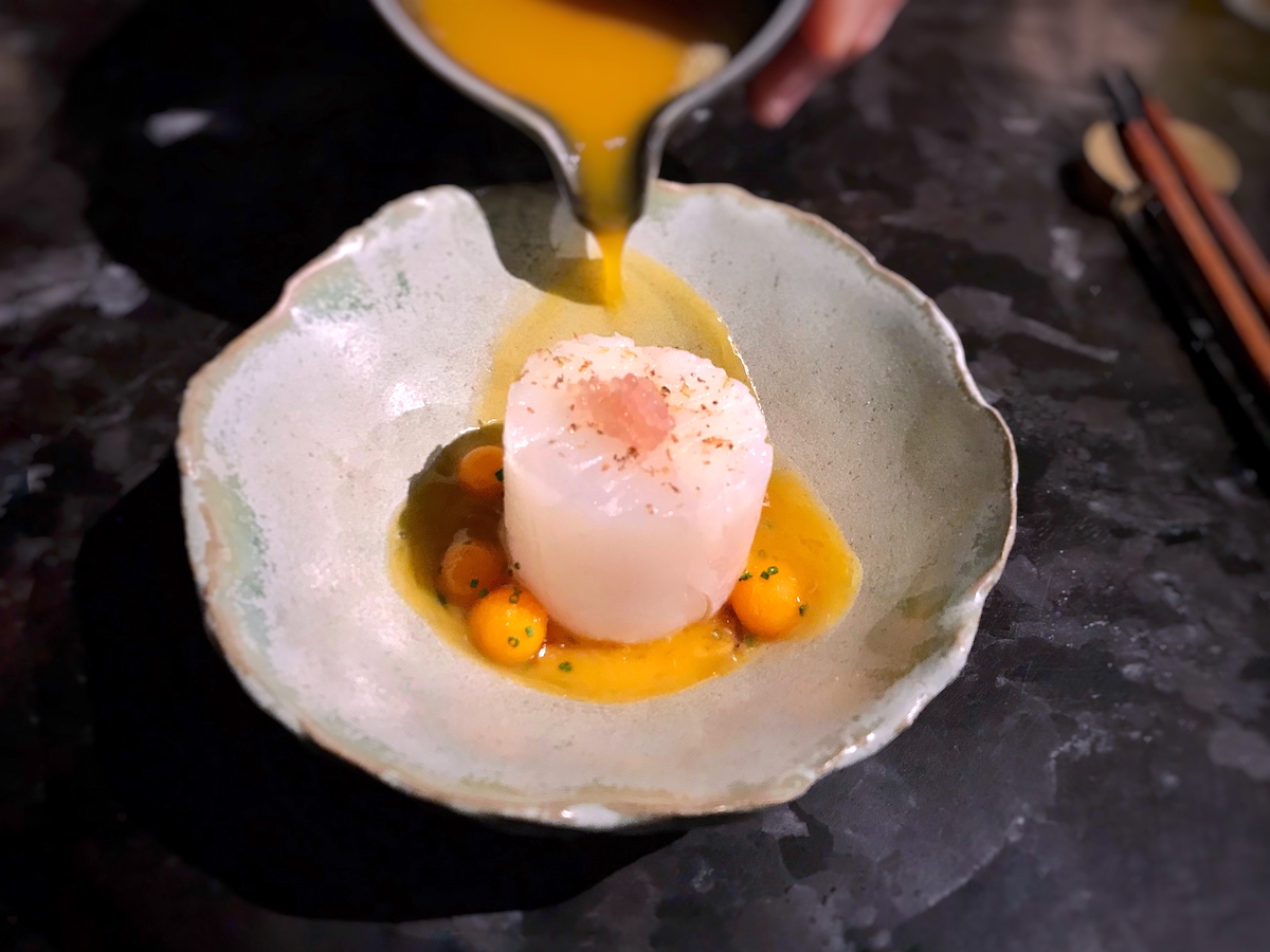 Se vierte una salsa marrón sobre un plato moderno de halibut