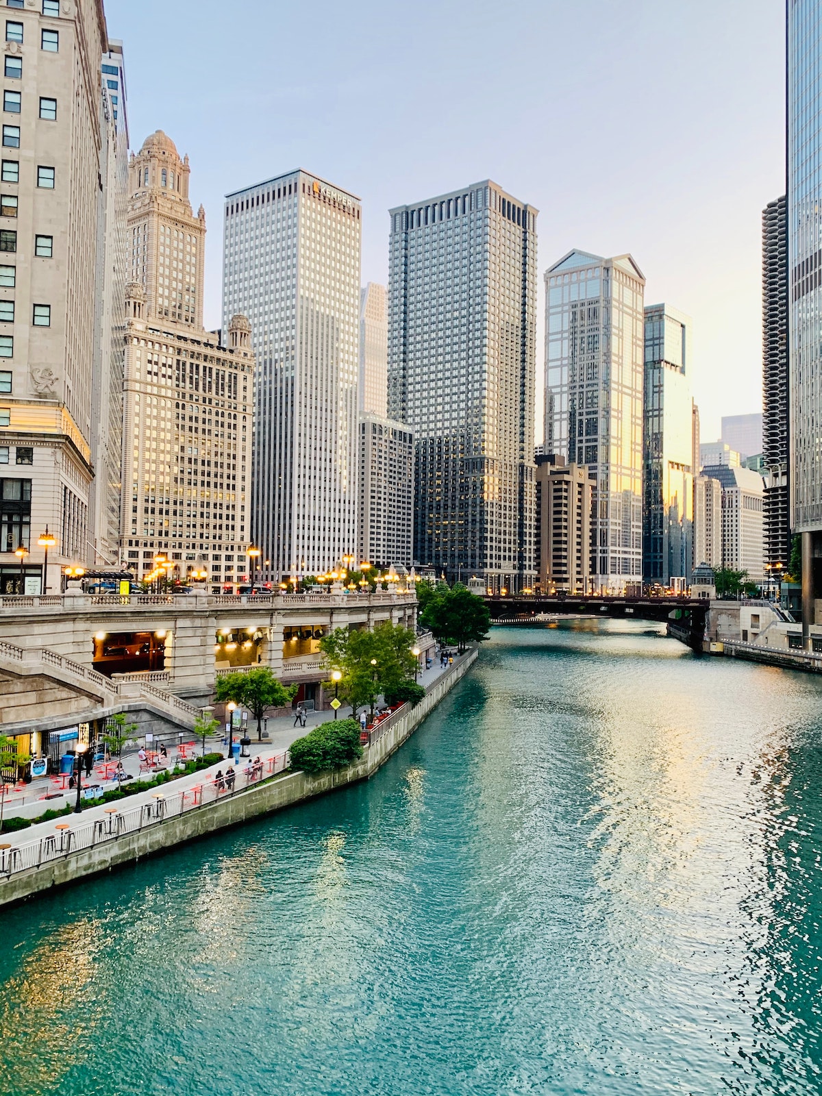 gente caminando por el río Chicago con rascacielos al fondo