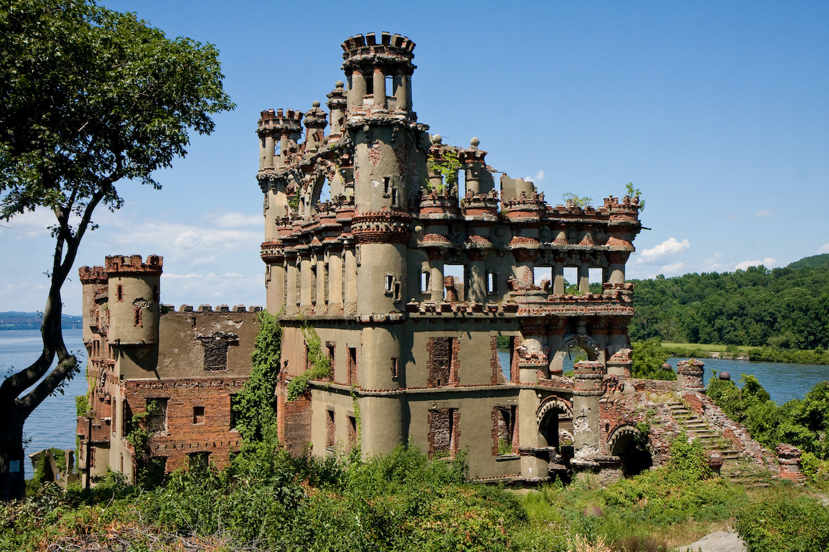 Ruinas de un gran castillo de piedra cerca de un cuerpo de agua en un día claro