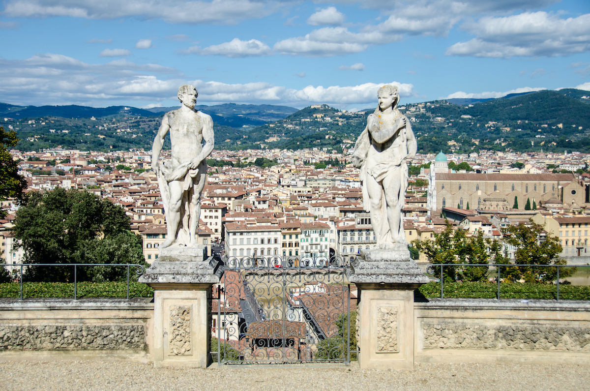 Dos estatuas de piedra que enmarcan una vista panorámica de la ciudad de Florencia, Italia