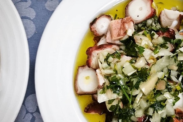 La ensalada de pulpo es uno de los mejores petiscos de Lisboa. Rociado con aceite de oliva y hierbas, como se muestra aquí, ¡es un gran plato para el verano!