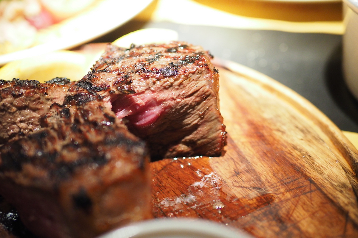 Cerrar bistec florentino en un plato de madera