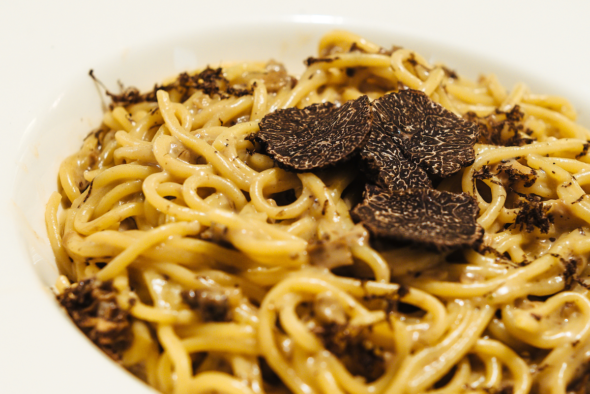 Fideos de pasta larga adornados con trufas negras