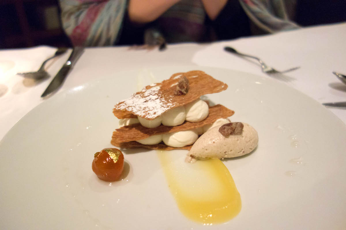Una presentación moderna de un plato con mousse entre dos finas capas de oblea