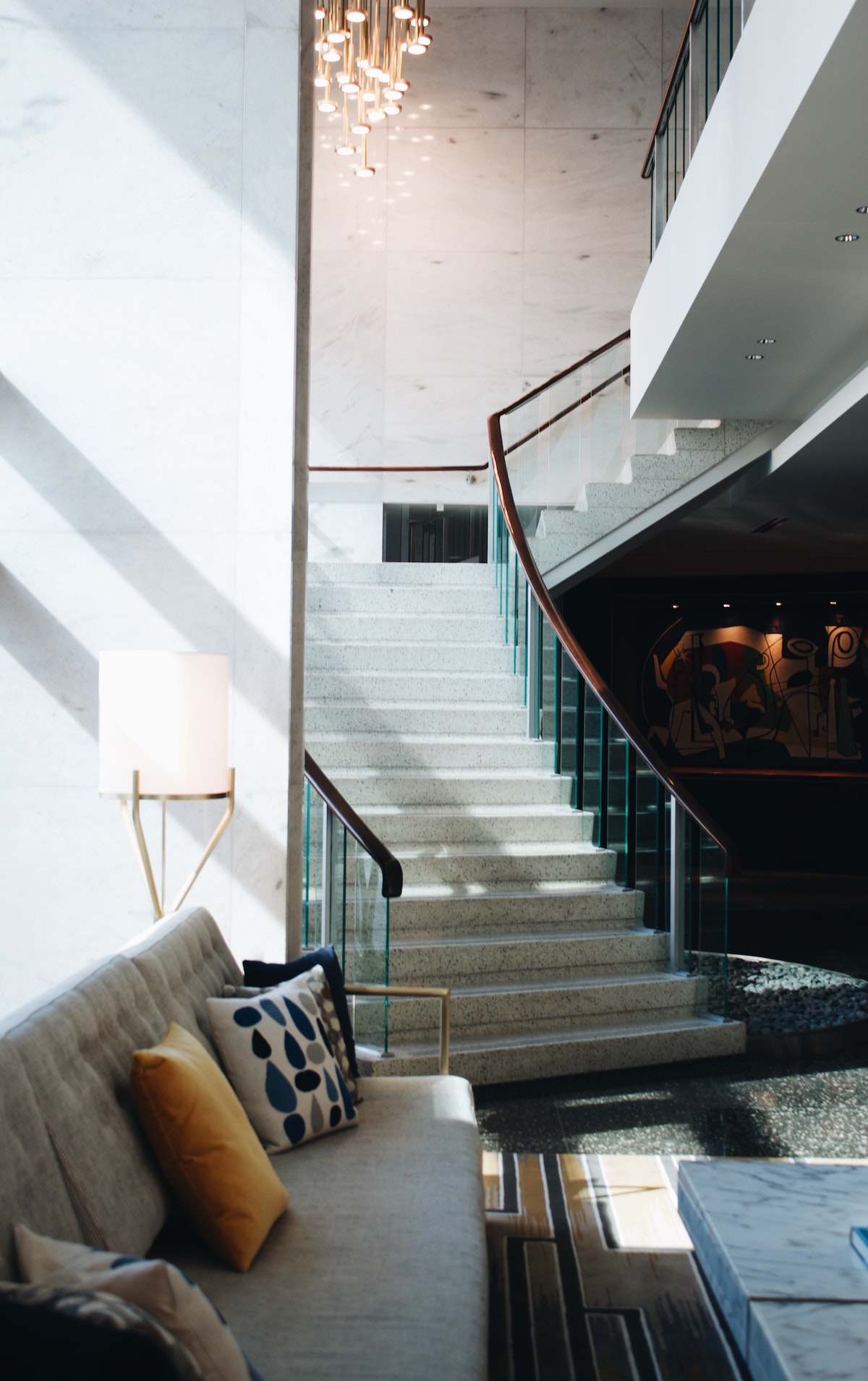 Vestíbulo del hotel boutique decorado en tonos neutros con una escalera de piedra que conduce al interior