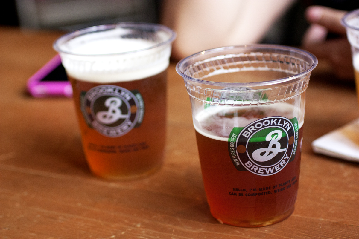Cerveza de Brooklyn Brewery en dos vasos de plástico sobre una mesa de madera