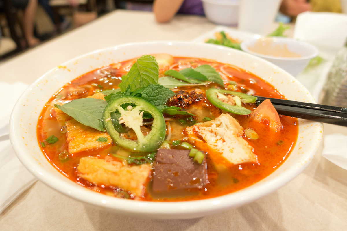 Sopa vietnamita a base de tomate con carne y verduras