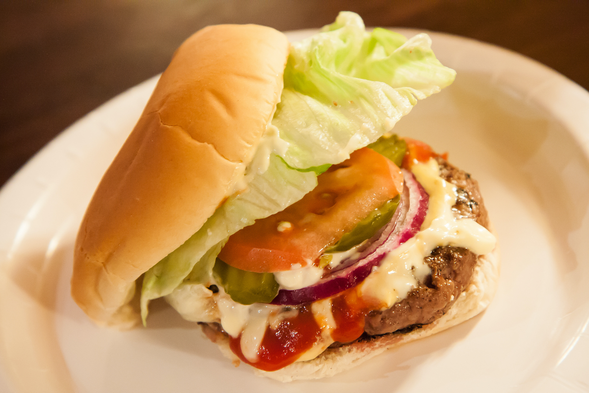 Hamburguesa con lechuga, tomate, cebolla, pepinillos y queso